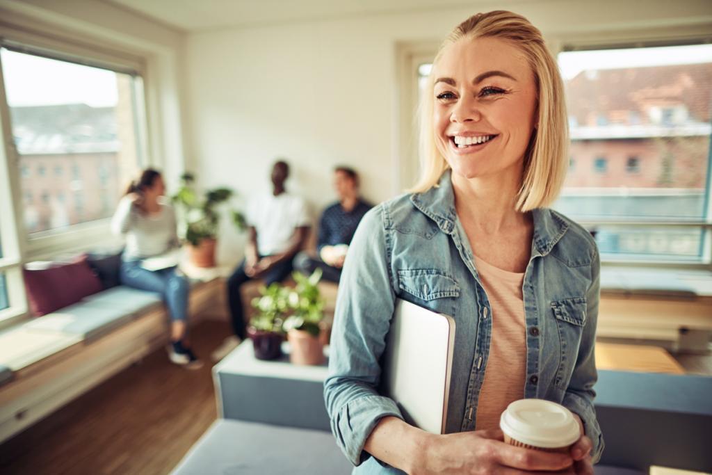 NLG Arbo -  vrolijke vrouw met koffie en een notitieboek