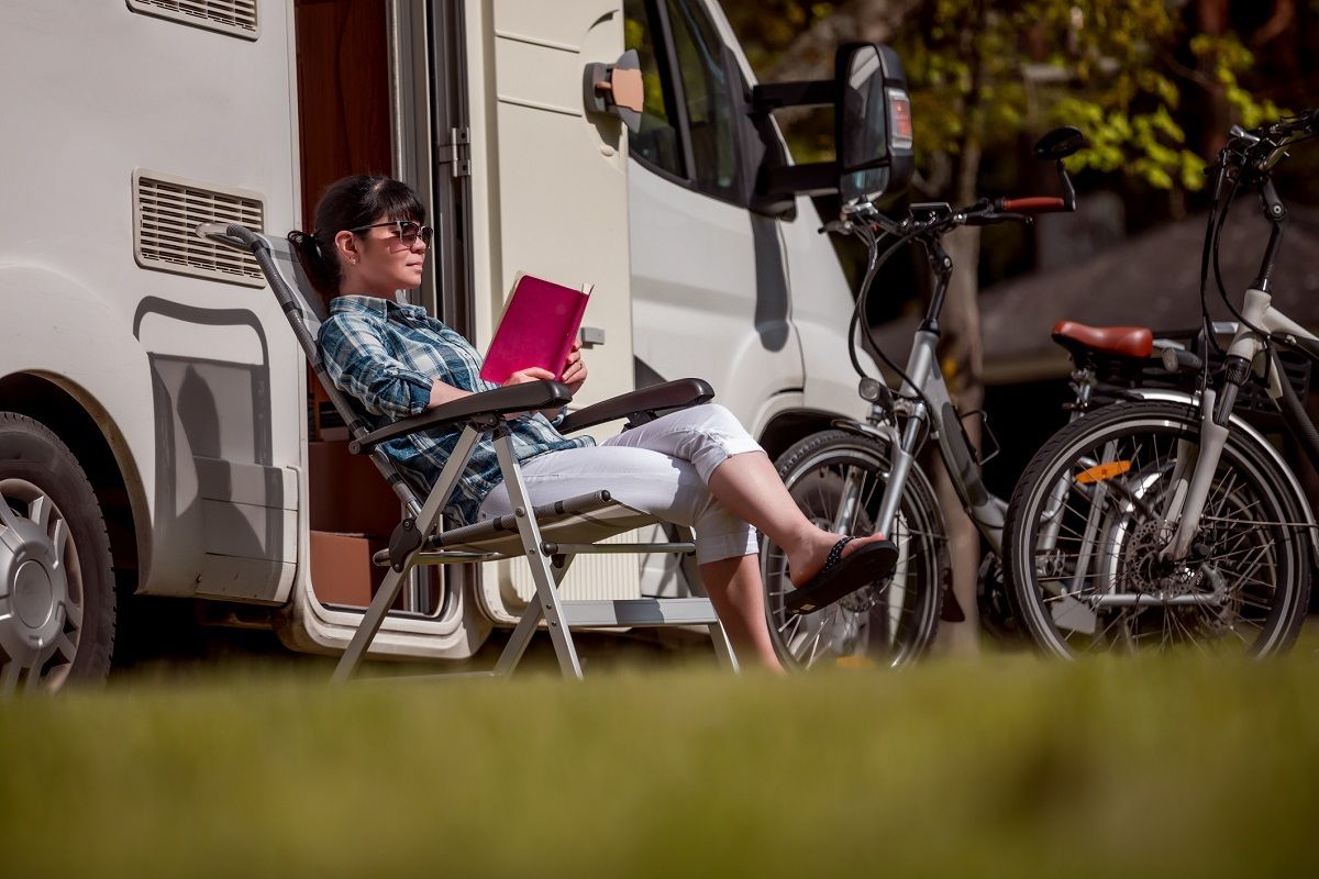Caravanverzekering - Vrouw zit voor de camper